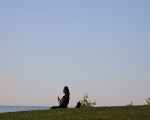 Calm woman relaxing outdoors with blue sky